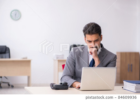 Young male employee working in the office Young male employee working in the office 84609936