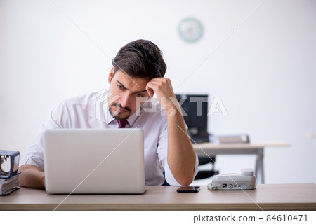 Young male employee working in the office Young male employee working in the office 84610471