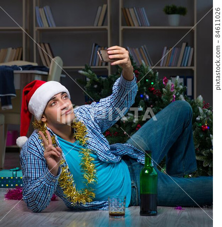 Man celebrating christmas at home alone 84611026