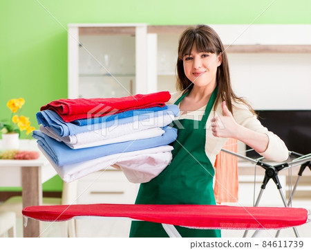 Young woman ironing clothing at home 84611739