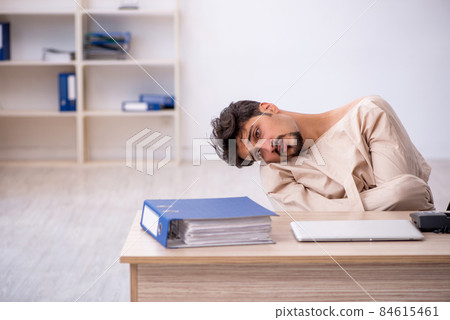 Crazy young man in straitjacket at the office 84615461