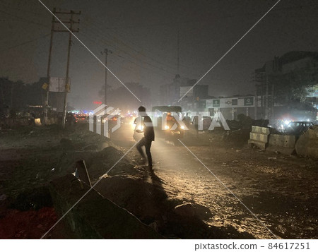 A person walking through the bustling streets of India at night, which have a fin-de-siècle feel to them. A person walking through the bustling streets of India at night, which have a fin-de-siècle feel to them. 84617251