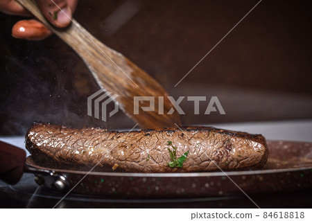 Italian coffee maker with wooden handle and white coffee craft cup on solid wood stamp decorated with tea towels in creamy tones on sunlight creating beautiful shadows on the wall 84618818
