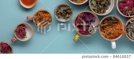 Italian coffee maker with wooden handle and white coffee craft cup on solid wood stamp decorated with tea towels in creamy tones on sunlight creating beautiful shadows on the wall 84618837