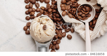 Italian coffee maker with wooden handle and white coffee craft cup on solid wood stamp decorated with tea towels in creamy tones on sunlight creating beautiful shadows on the wall Italian coffee maker with wooden handle and white coffee craft cup on solid wood stamp decorated with tea towels in creamy tones on sunlight creating beautiful shadows on the wall 84618858