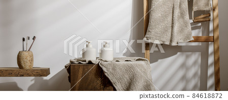 Italian coffee maker with wooden handle and white coffee craft cup on solid wood stamp decorated with tea towels in creamy tones on sunlight creating beautiful shadows on the wall Italian coffee maker with wooden handle and white coffee craft cup on solid wood stamp decorated with tea towels in creamy tones on sunlight creating beautiful shadows on the wall 84618872