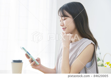 Female thinking smartphone living room Female thinking smartphone living room 84620005