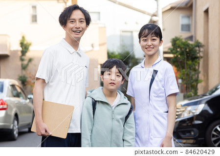 Healthcare workers and children in a residential area 84620429