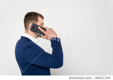 Close up of young business man in suit speaks on cell phone on white background Close up of young business man in suit speaks on cell phone on white background 84621344