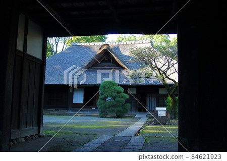 A Japanese house with a thatched roof 84621923
