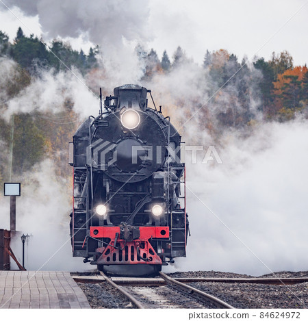Retro steam train arrives to the station wooden platform. Retro steam train arrives to the station wooden platform. 84624972