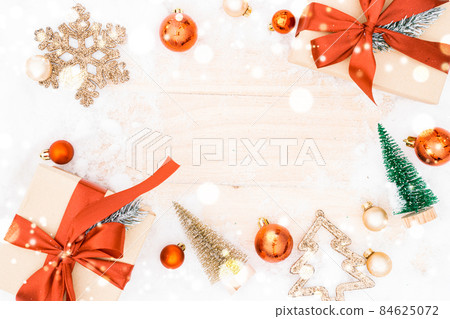Christmas frame. Winter wooden decoration background. Xmas board with old rustic wall, white frozen snow, golden balls and gift box. Top view with copy space. 84625072