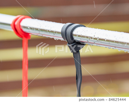 Exercise and stretching rubber elastic bands hanging on a workout rail. Exercise and stretching rubber elastic bands hanging on a workout rail. 84625444