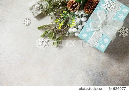 Christmas or New Year holidays composition layout. Fir tree snow branch, Christmas present and decoration on a stone tabletop. Flat lay, copy space. Christmas or New Year holidays composition layout. Fir tree snow branch, Christmas present and decoration on a stone tabletop. Flat lay, copy space. 84626077