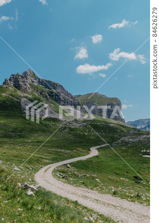 Amaizing view on Durmitor mountains, National Park, Mediterranean, Montenegro, Balkans, Europe. Bright summer view from Sedlo pass. The road near the house in the mountains. 84626279