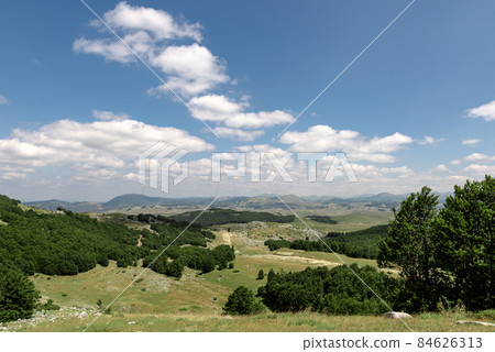 Mountain landscape. Mountains with green grass and bright blue sky. Idyllic panorama. Tourism concept. Hiking. Vacation in Europe. Relax in the open air and the spirit of adventure. Ecology of nature Mountain landscape. Mountains with green grass and bright blue sky. Idyllic panorama. Tourism concept. Hiking. Vacation in Europe. Relax in the open air and the spirit of adventure. Ecology of nature 84626313