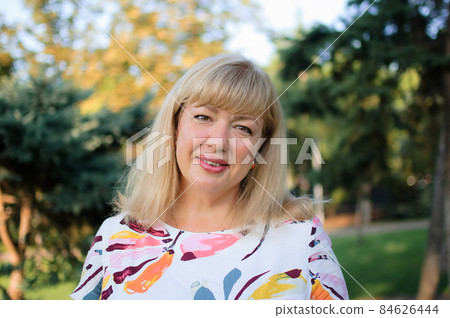 Plus size young woman in dress at nature in the park during summer. Life of people xl size, happy nice natural beauty woman. Concept of overweight 84626444