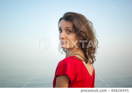 Young girl in red dress on the sea and blue background, summertime, travelling concepts 84626445