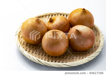 Onions on a colander with a white background Onions on a colander with a white background 84627386