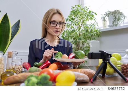 Woman nutritionist recording a video about healthy food, nutrition Woman nutritionist recording a video about healthy food, nutrition 84627752