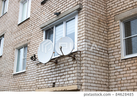 Two satellite TV antennas on the wall of the house Two satellite TV antennas on the wall of the house 84628485