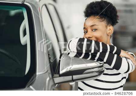 Young african american woman in car salon Young african american woman in car salon 84628706