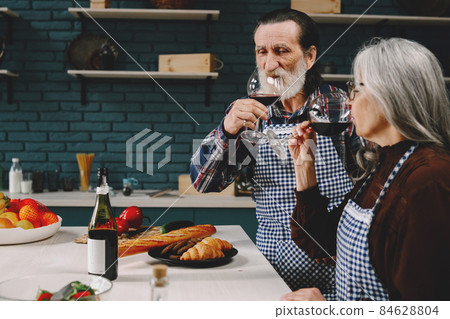 Modern senior drinking wine together in kitchen Modern senior drinking wine together in kitchen 84628804