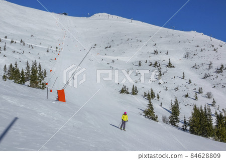 Girl Skier Rides a Wide Ski Slope Girl Skier Rides a Wide Ski Slope 84628809