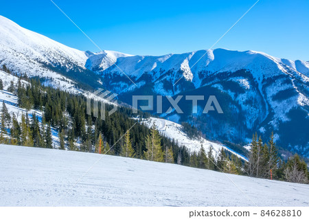 Sunny Weather Over Empty Ski Slope and Mountain Relief Sunny Weather Over Empty Ski Slope and Mountain Relief 84628810