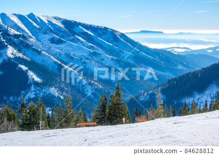 Sunny Weather Over Empty Ski Slope and Mountain Peaks Sunny Weather Over Empty Ski Slope and Mountain Peaks 84628812