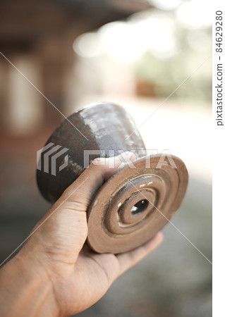 Close up hand holding dripper ceramic 84629280