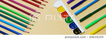 Colored pencils and markers with pens and paint on paper background with copy Colored pencils and markers with pens and paint on paper background with copy 84630204