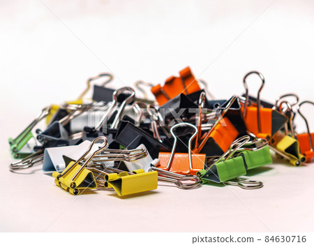 Set of multicolored paperclips on a white background. Selective focus. Close-up 84630716
