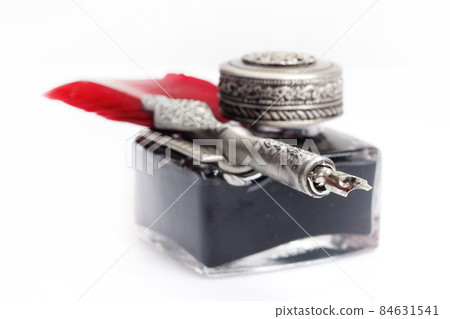 Old red fountain pen with inkwell on white background 84631541