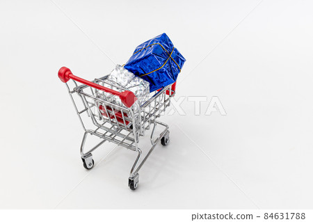 Grocery cart with New Year's holiday gifts on a white isolated plain background. Flat lay. Save the space. Postcard Template 84631788