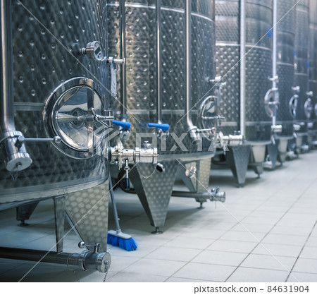 Stainless steel tanks for fermenting grapes. Winery interior 84631904