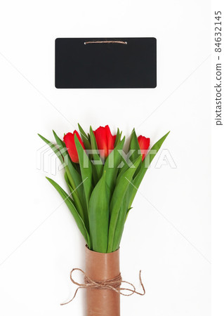 Bouquet of red tulips packed in kraft paper in retro style and chalky writing board isolated on white background 84632145