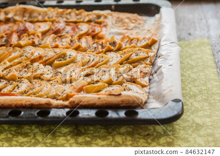 flat apple pie on a baking sheet 84632147