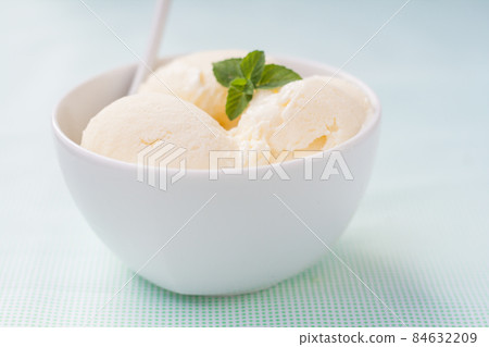 balls of vanilla ice cream decorated with mint leaves balls of vanilla ice cream decorated with mint leaves 84632209