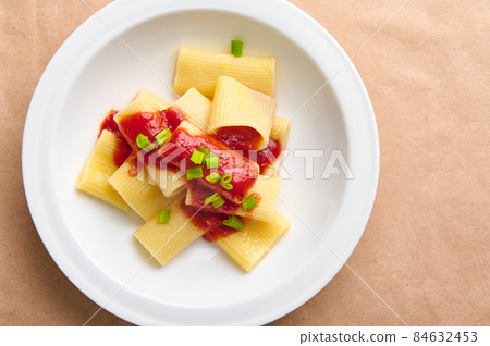 Flat lay composition of a healthy vegan meal consisting of vegetarian cooked italian pasta with tomato sauce and green onion garnish. Healthy traditional eating concept Flat lay composition of a healthy vegan meal consisting of vegetarian cooked italian pasta with tomato sauce and green onion garnish. Healthy traditional eating concept 84632453