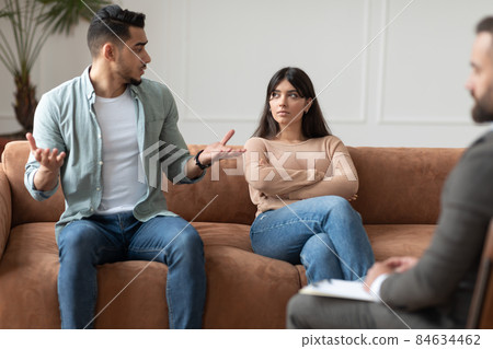 Couple talking at therapy session with male therapist Couple talking at therapy session with male therapist 84634462