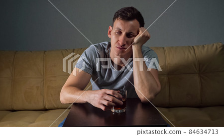 Young tipsy man drinks alcohol trying to solve problems Young tipsy man drinks alcohol trying to solve problems 84634713