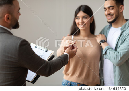 Real Estate Agent Giving Keys To Excited Buyers Real Estate Agent Giving Keys To Excited Buyers 84634850