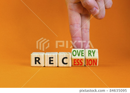Recovery and recession symbol. Businessman turns cubes and changes the word 'recession' to 'recovery'. Beautiful orange table, orange background. Business and recovery - recession concept. Copy space. 84635095