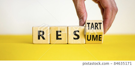 Resume and restart symbol. Businessman hand turns cubes and changes the word 'resume' to 'restart'. Beautiful yellow table, white background. Business and resume - restart concept. Copy space. Resume and restart symbol. Businessman hand turns cubes and changes the word 'resume' to 'restart'. Beautiful yellow table, white background. Business and resume - restart concept. Copy space. 84635171