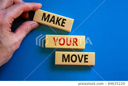Make your move symbol. Wooden blocks with words 'Make your move'. Beautiful blue background, businessman hand. Business, make your move concept, copy space. Make your move symbol. Wooden blocks with words 'Make your move'. Beautiful blue background, businessman hand. Business, make your move concept, copy space. 84635220