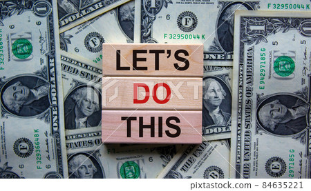 Blocks tower with words 'lets do this' on beautiful background from dollar bills. Copy space. Business concept. Blocks tower with words 'lets do this' on beautiful background from dollar bills. Copy space. Business concept. 84635221
