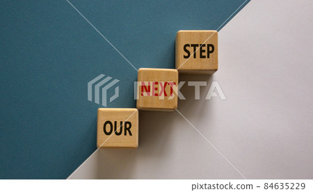 Conceptual image of motivation. Wooden cubes with words 'our next step'. Beautiful white and blue background, copy space. Business concept. Conceptual image of motivation. Wooden cubes with words 'our next step'. Beautiful white and blue background, copy space. Business concept. 84635229