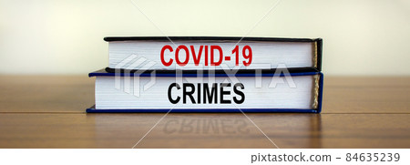 Books with text 'covid19 crimes' on beautiful wooden table, white background. Business and covid19 pandemic concept. Copy space. 84635239