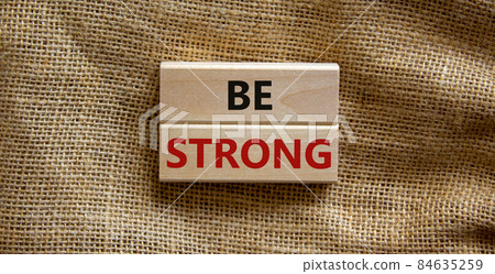 Be strong symbol. Wooden blocks with words 'be strong'. Beautiful canvas background. Copy space. Motivational, business and be strong concept. Copy space. 84635259